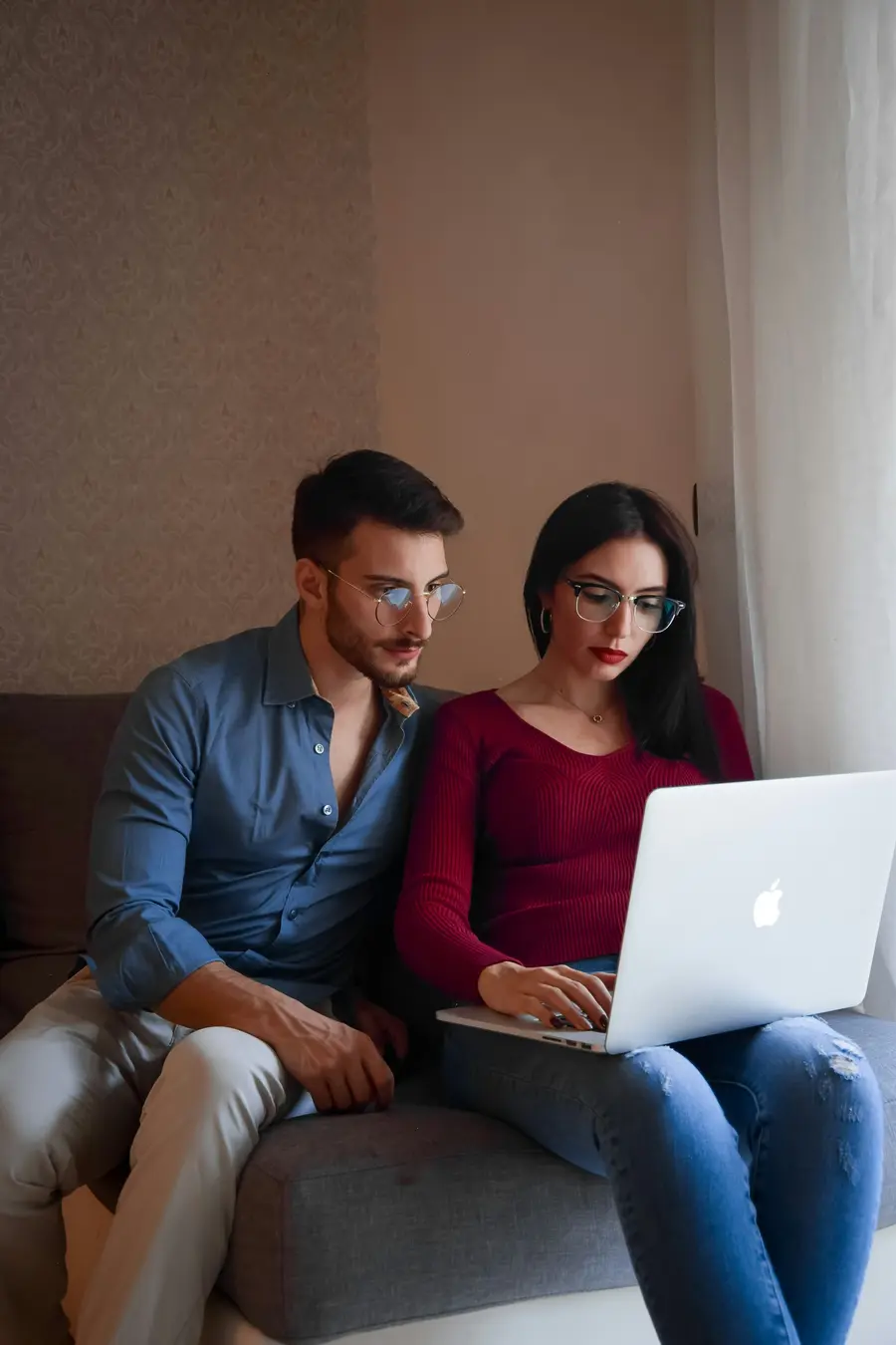 Casal jovem revisando contas no notebook em casa clara