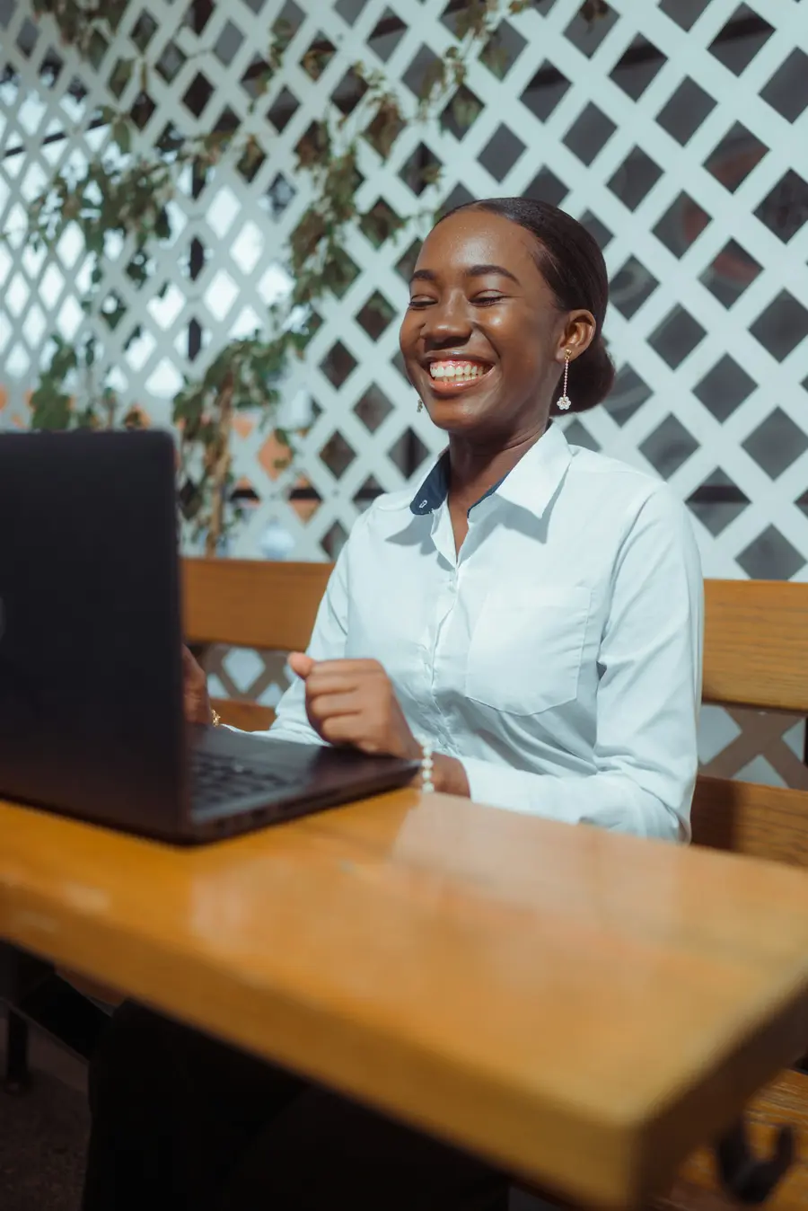 Mulher sorridente fazendo contas com calculadora e notebook em casa clara