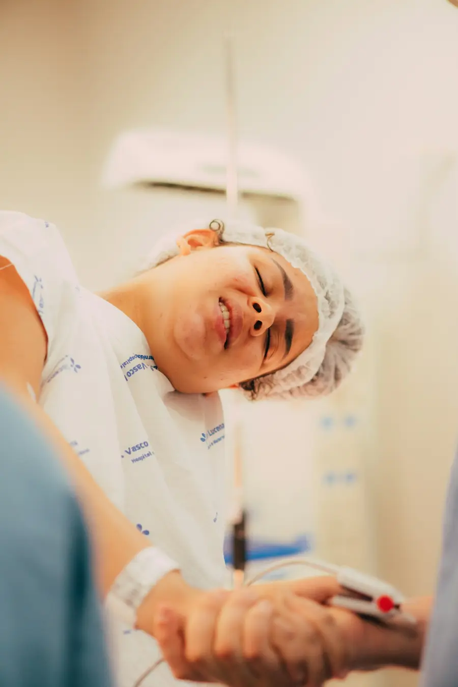 Enfermeira sorridente com paciente em quarto de hospital claro