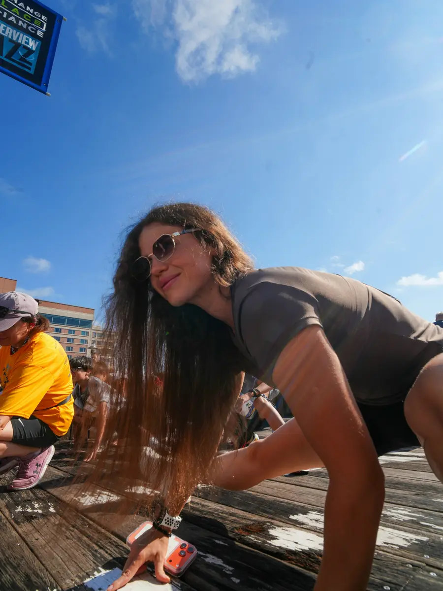 Mulher de óculos escuros se alongando ao sol