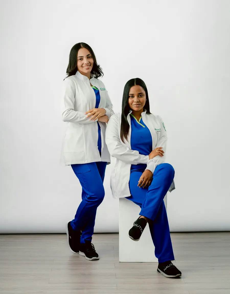 Duas profissionais de saúde de uniforme azul sorrindo