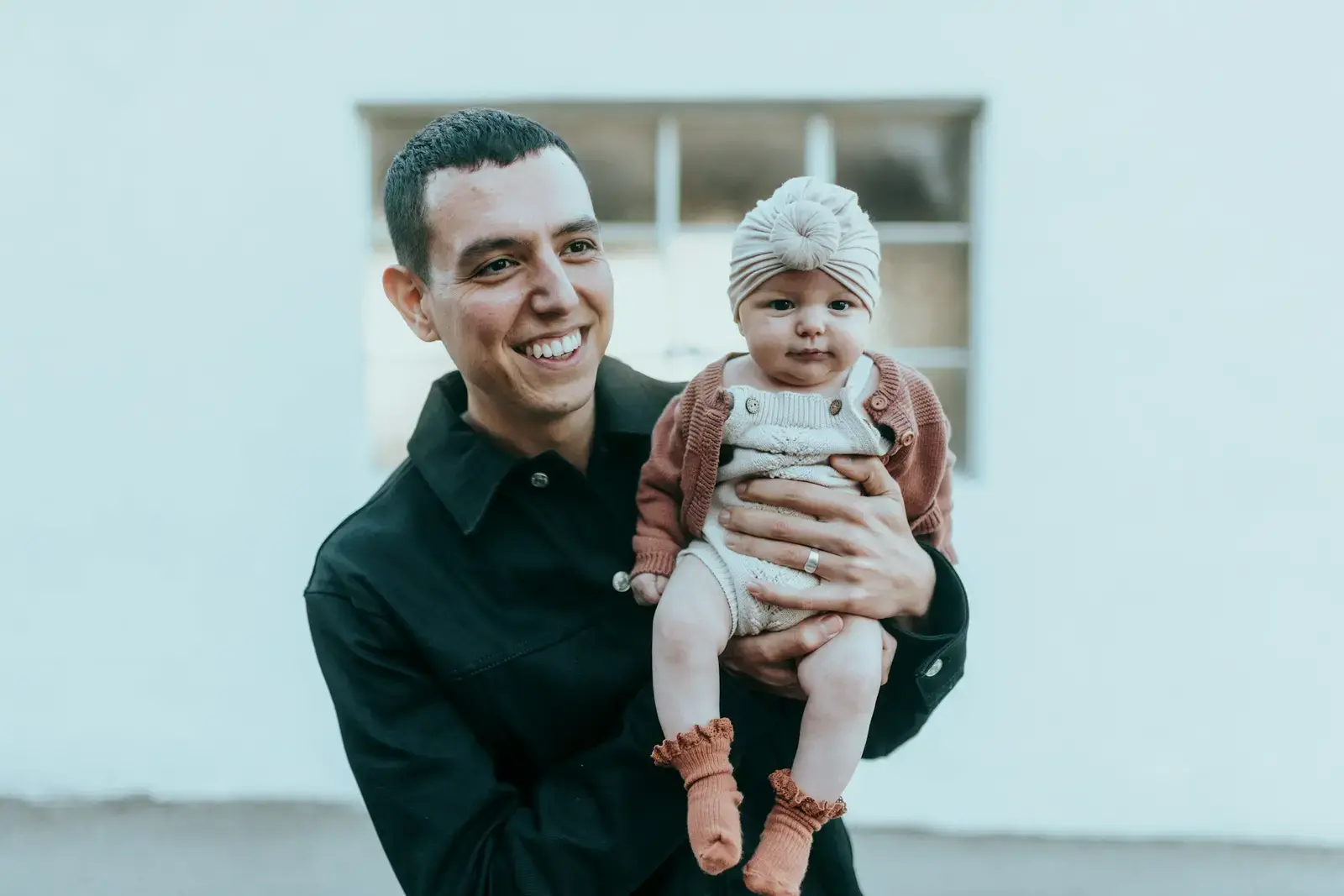 Pai sorrindo com a filha bebê no colo